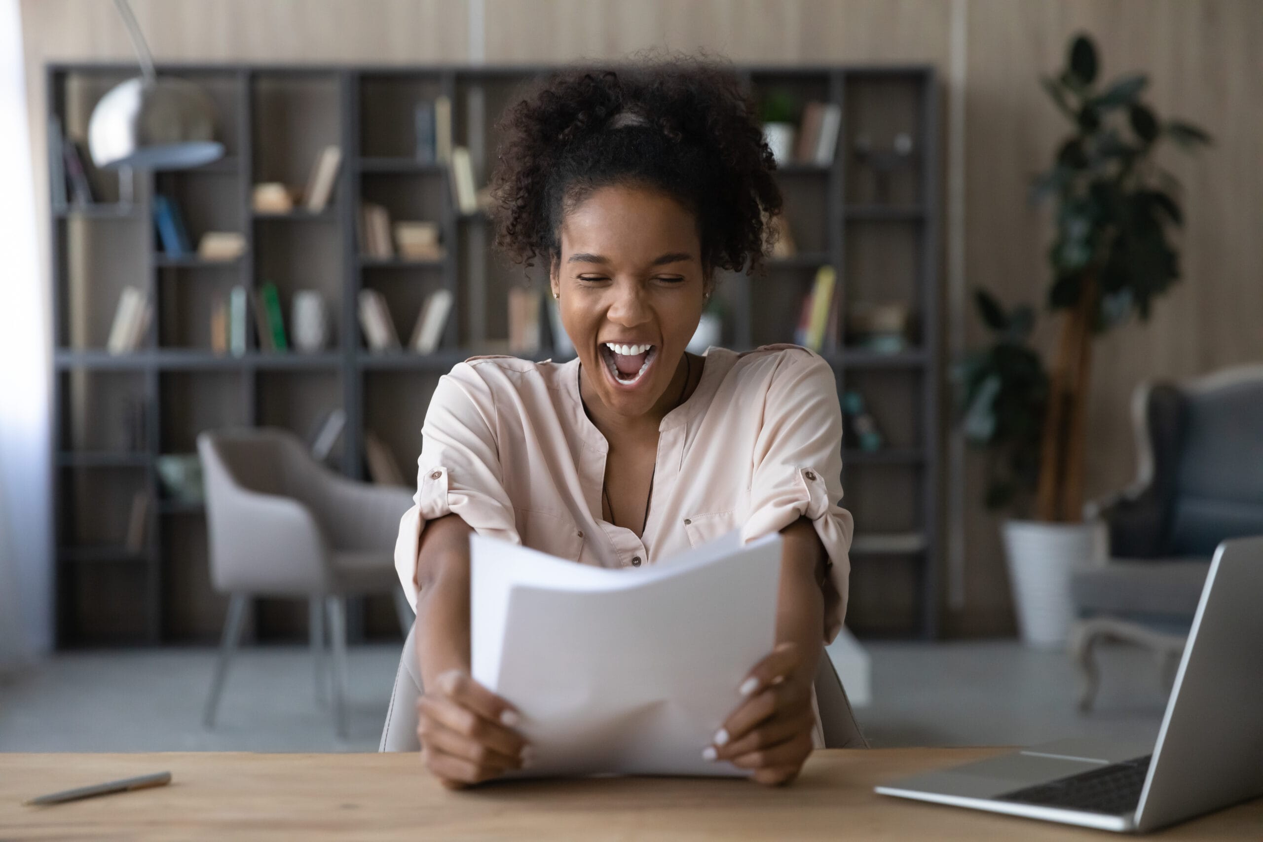 Happy excited African student girl receiving admission letter from university